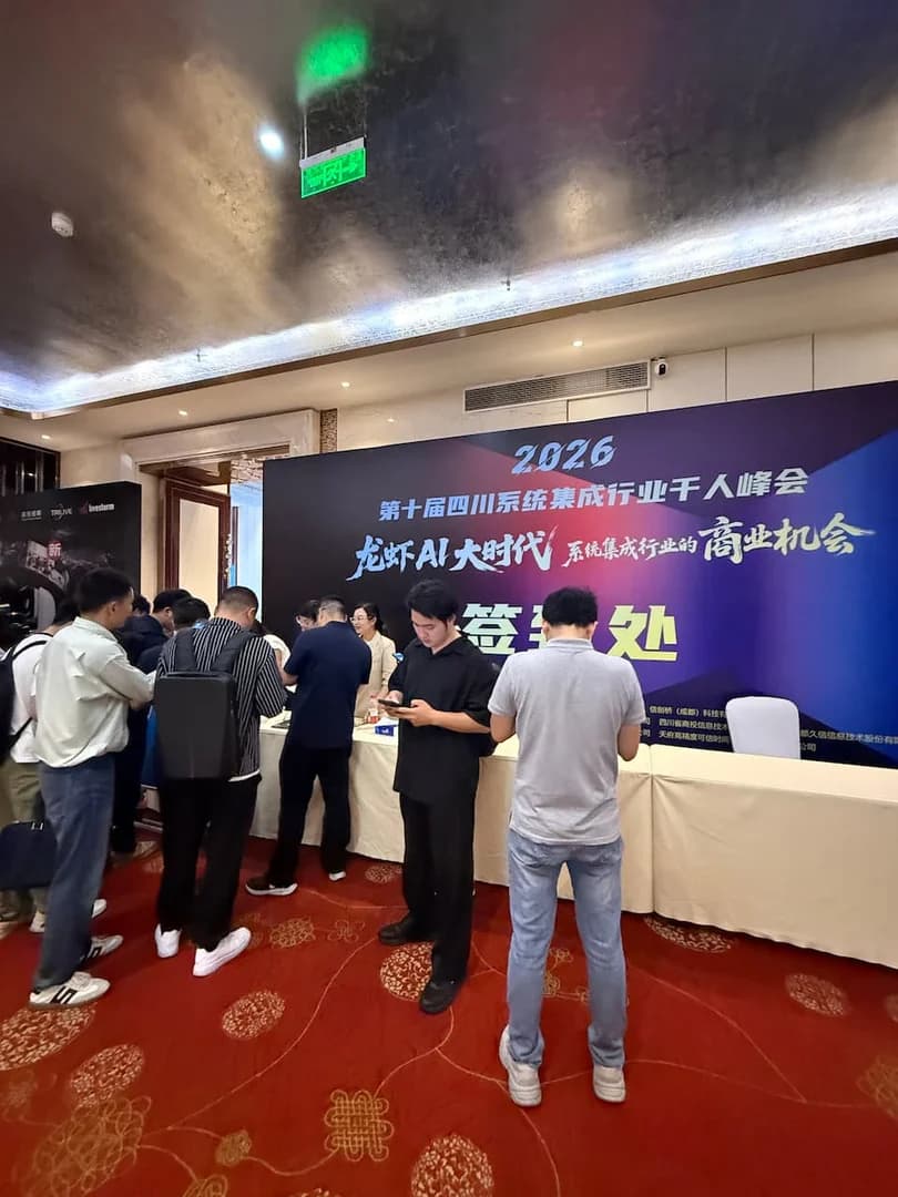 2026 第十届四川系统集成行业千人峰会签到处现场,多列签到台前排队的参会代表,工作人员核验信息发放胸牌与会议手册
