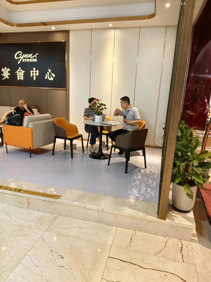 美步科技工程师在 2026 四川系统集成行业千人峰会会场圆桌与潜在客户深度交流,桌面有笔记本电脑、威联通 QNAP 产品资料和茶水,体现非展位深度技术沟通场景